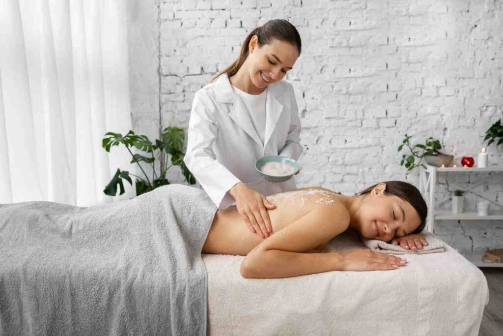 Female therapist performing Udvartana herbal powder massage at Ayurvedic spa Mumbai